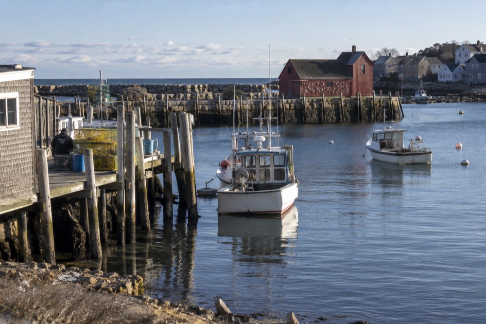 A fishing boat harbor in Gloucester with wharves and docks