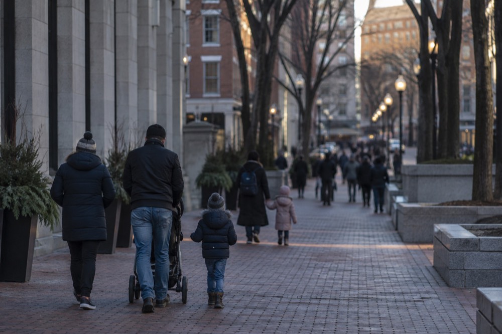 Families walking a brick pedestrian mall in downtown Boston on a sunny afternoon