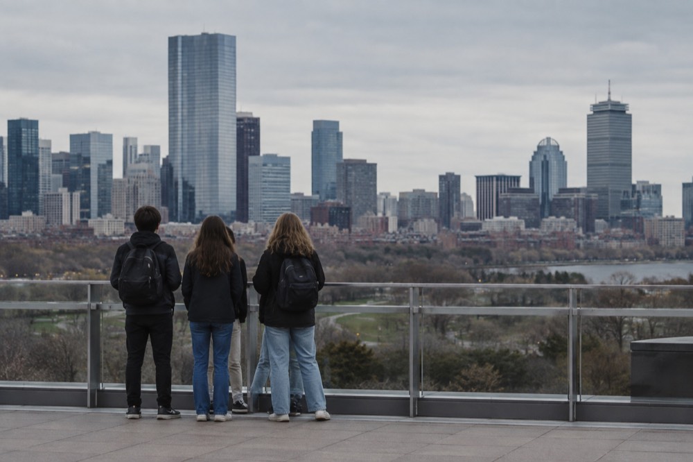 Teenagers looking out over the Boston skyline from a rooftop observation deck