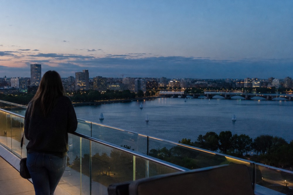 Glass railing on a high observation deck with the Charles River and Cambridge in the distance