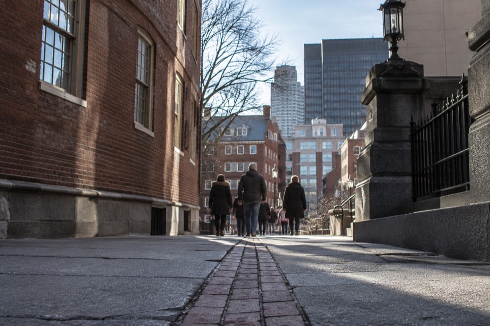 Visitors walking the red-lined Freedom Trail past historic brick buildings