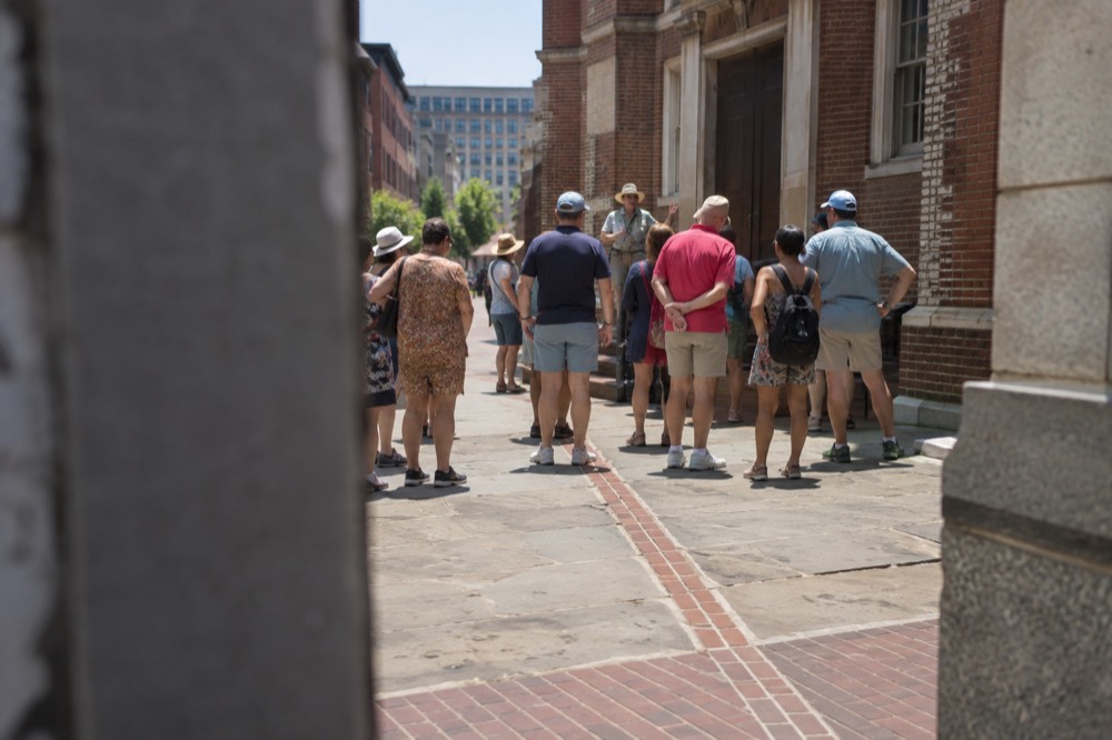 Tour group gathered around a guide outside a colonial brick building in Boston