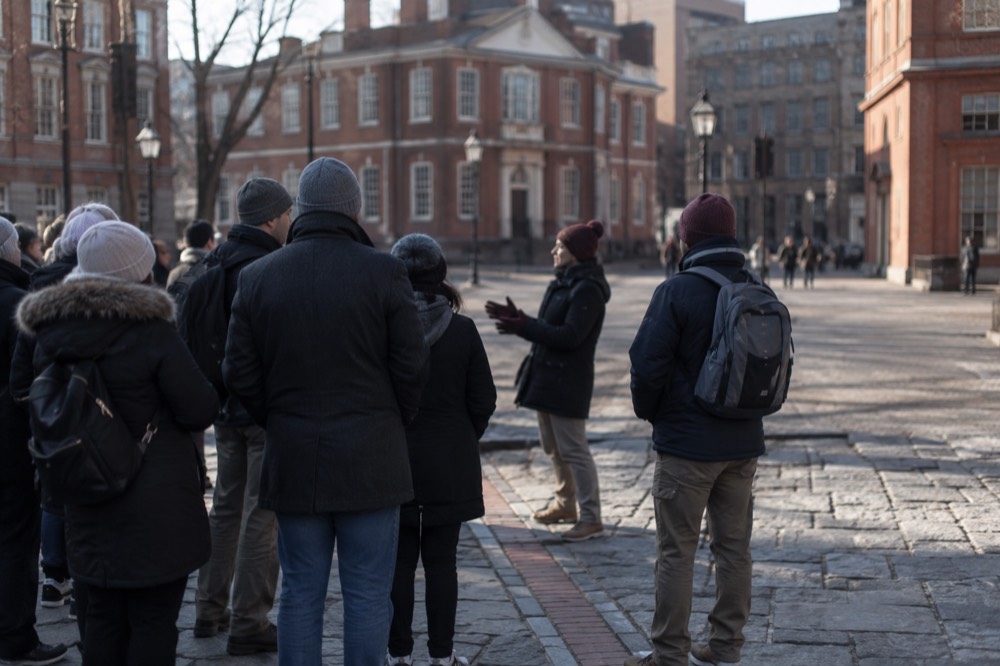 Guide speaking to a small group in a historic Boston square