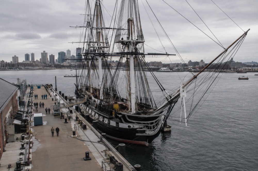 USS Constitution docked at the Charlestown Navy Yard with visitors on the pier