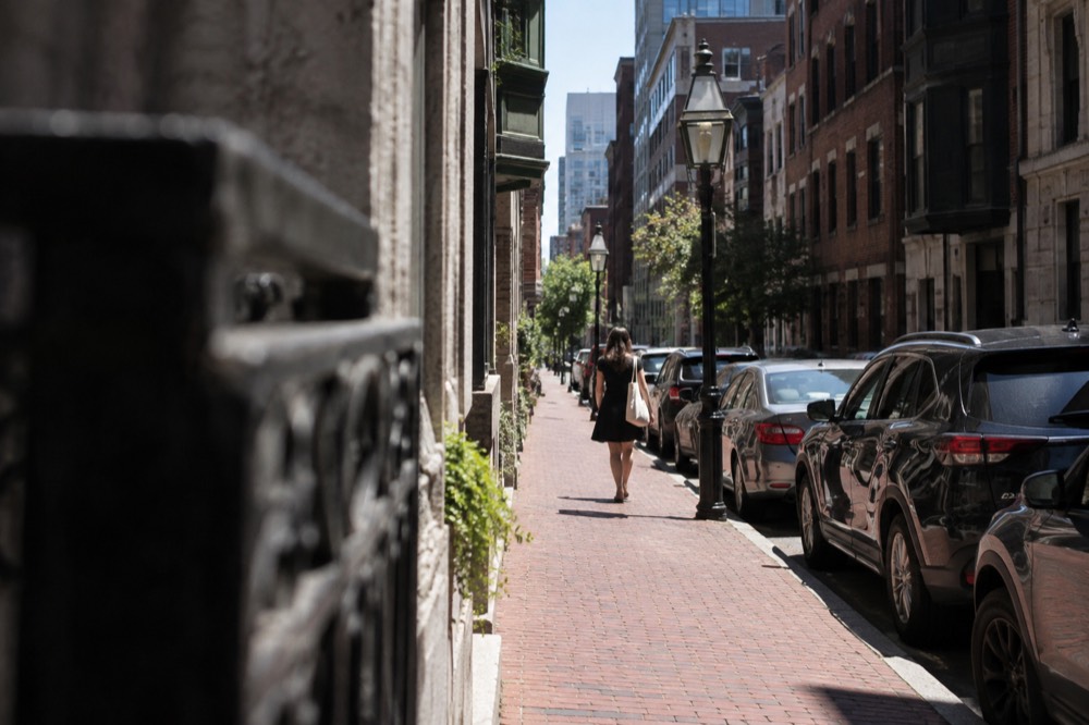 Narrow downtown Boston street with cars parked along the curb