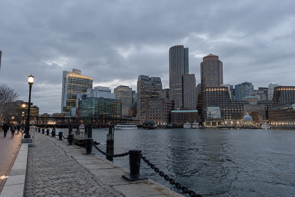A waterfront hotel district with glass towers and a harbor walkway in evening light