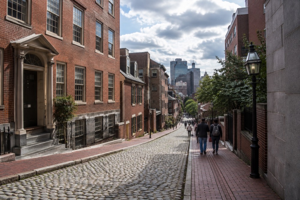 Visitors walking the red brick line of the Freedom Trail past colonial-era buildings