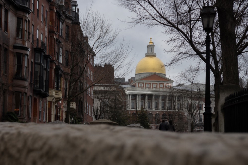 The gilded dome of the Massachusetts State House above Beacon Hill rooftops