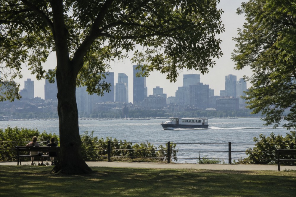 A water taxi crossing Boston Harbor toward the downtown skyline