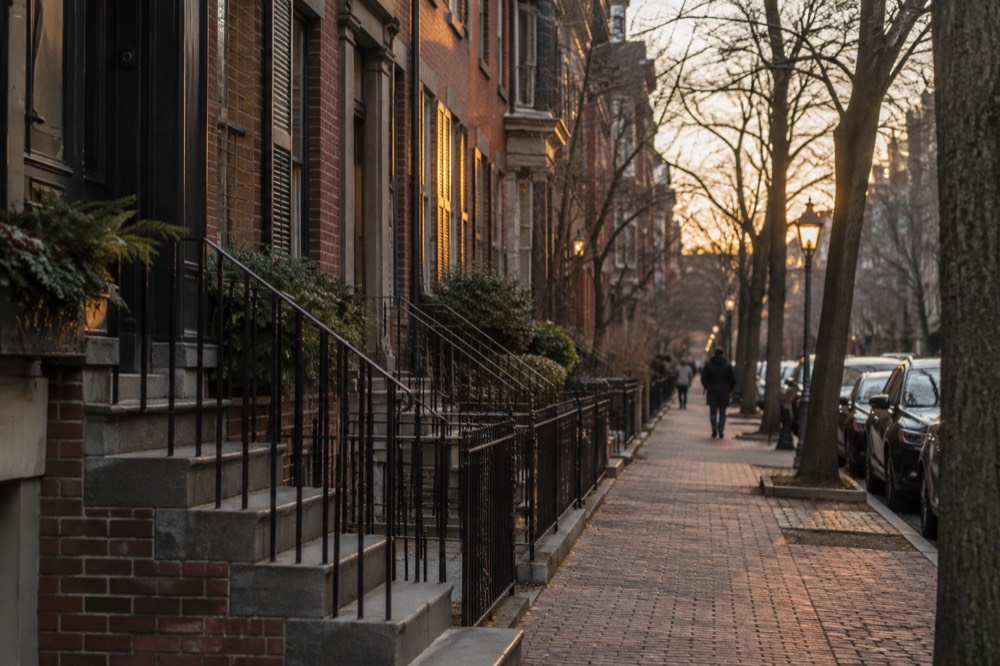 A brick rowhouse street in a downtown Boston neighborhood at golden hour