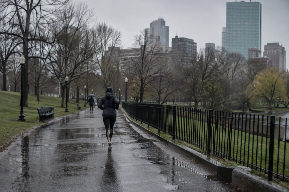 Rain falling on a Boston street with wet cobblestones and brick row houses under gray skies