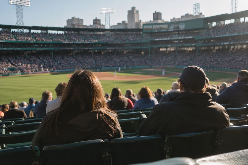 Baseball fans filling the grandstand seats at Fenway Park during a day game
