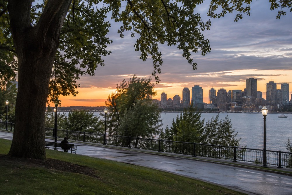 Boston skyline glowing at dusk across the harbor