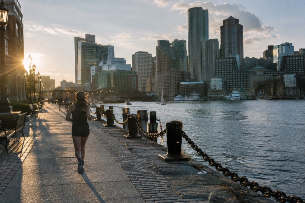 Harborwalk path along the water with the lit city behind