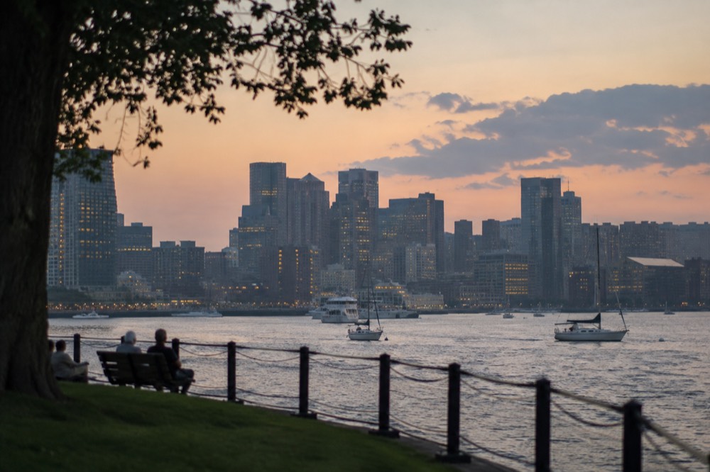 Boston's harbor and city lights at dusk seen from the water