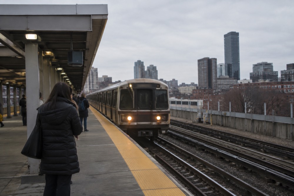 A subway platform in Boston with a train arriving