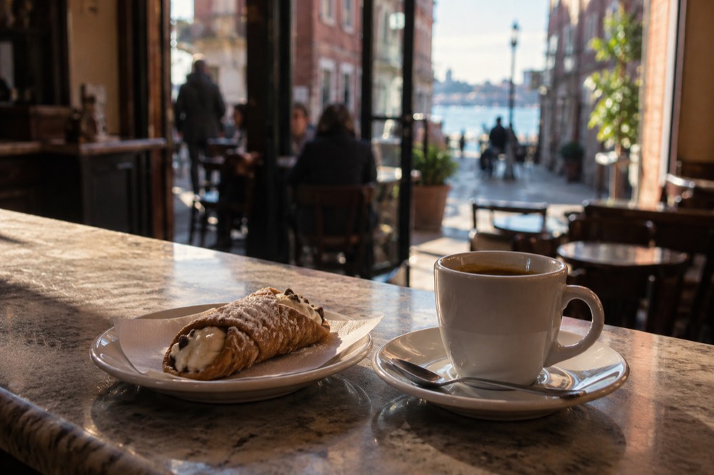 A cannoli and espresso on a cafe counter in Boston's North End