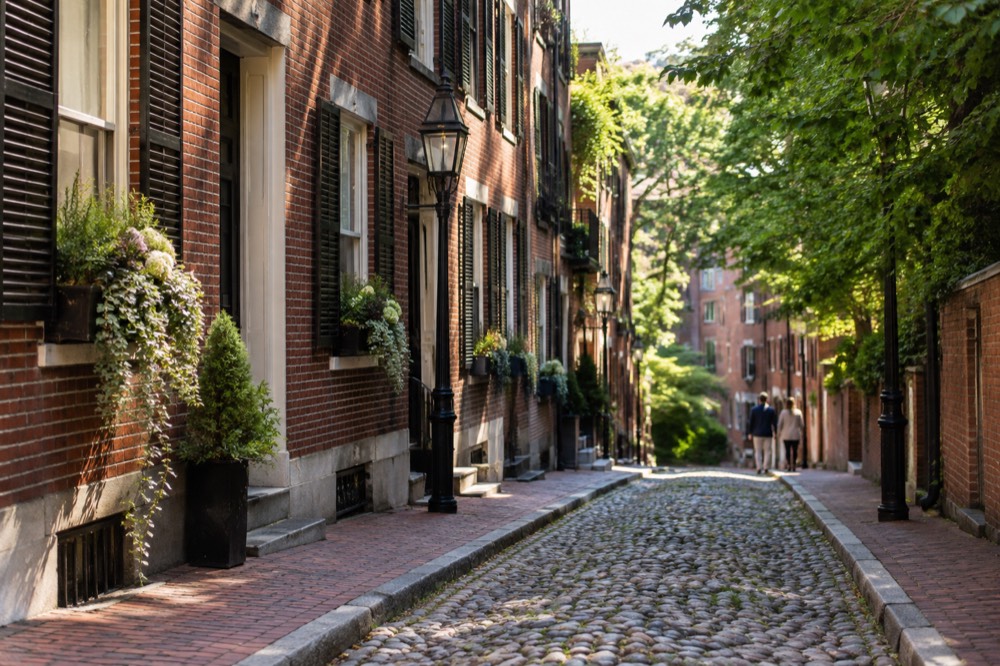 A narrow gaslit brick lane with row houses in Beacon Hill Boston