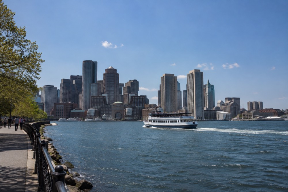 A sightseeing boat crossing Boston Harbor with the city skyline behind it