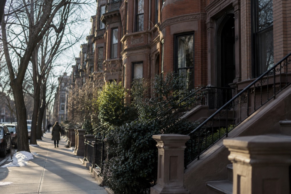 Brownstone row houses on a tree-lined Back Bay street with brick facades and bay windows