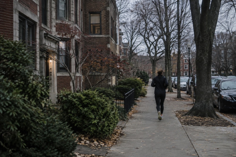 A quiet residential street in Brookline with low brick apartment buildings and trees