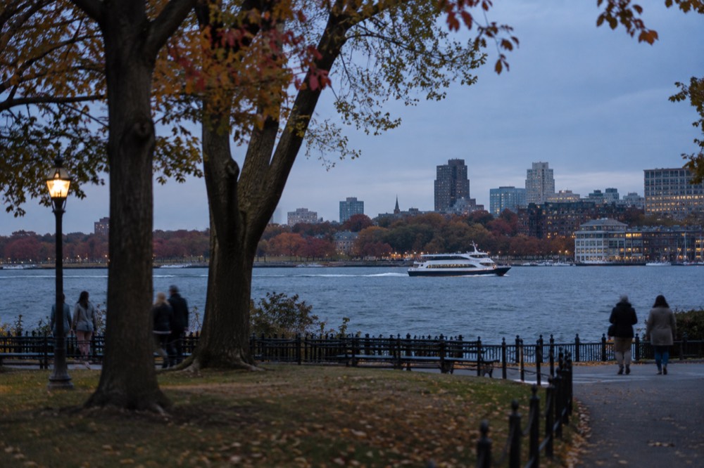 A fast ferry crossing the water toward Salem with autumn trees on the shore