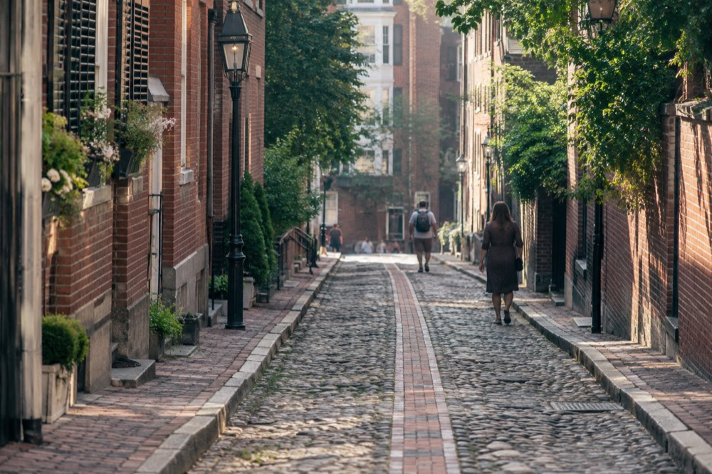 The red brick Freedom Trail line running along a cobblestone street in downtown Boston