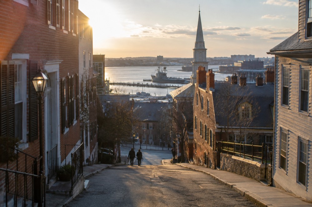 Historic brick buildings and a church spire in the Charlestown Navy Yard