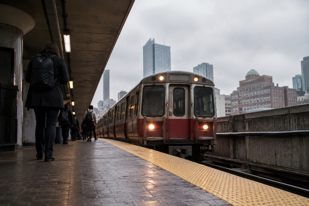 A Boston subway platform with a red line train arriving