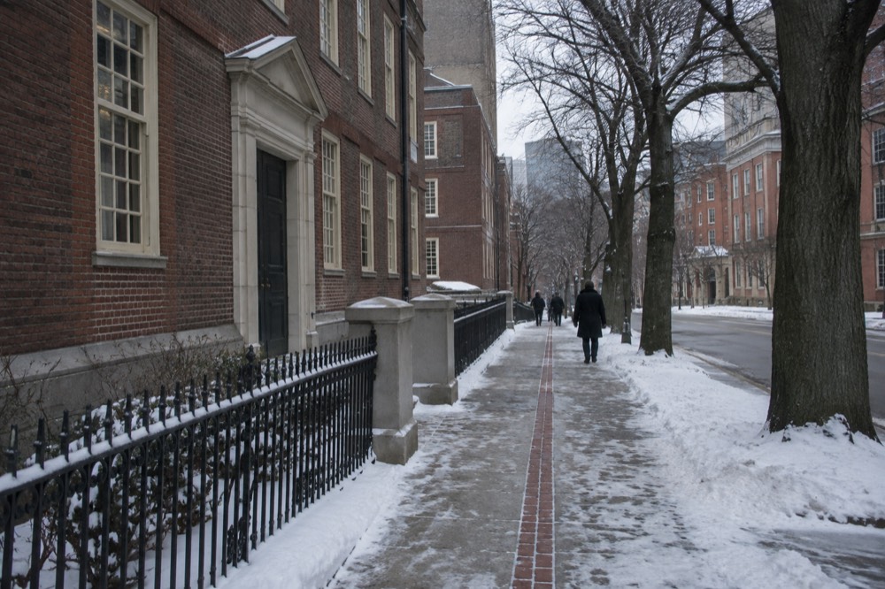 The red brick Freedom Trail line running along a snowy sidewalk past a colonial-era building