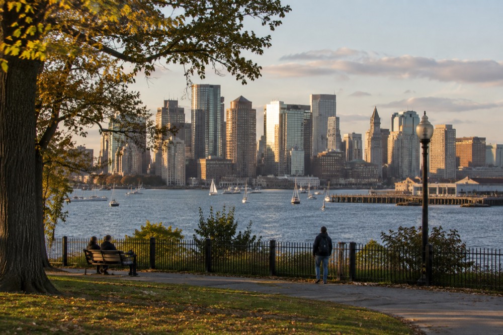 Golden late afternoon light on the Boston skyline across the harbor water